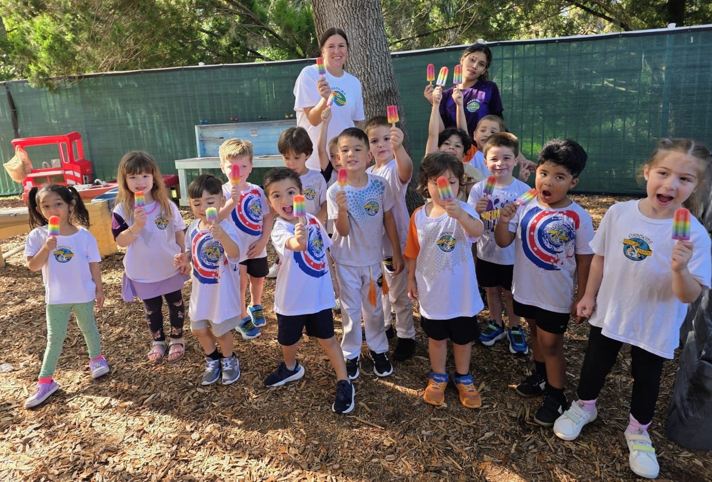 Children and adults outdoors holding colorful frozen treats.